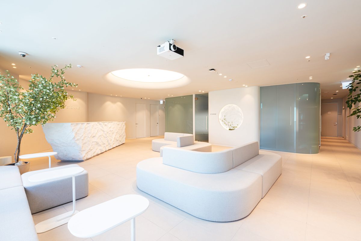 Lounge with a rock-textured reception counter, round wall accent, and curved sofas