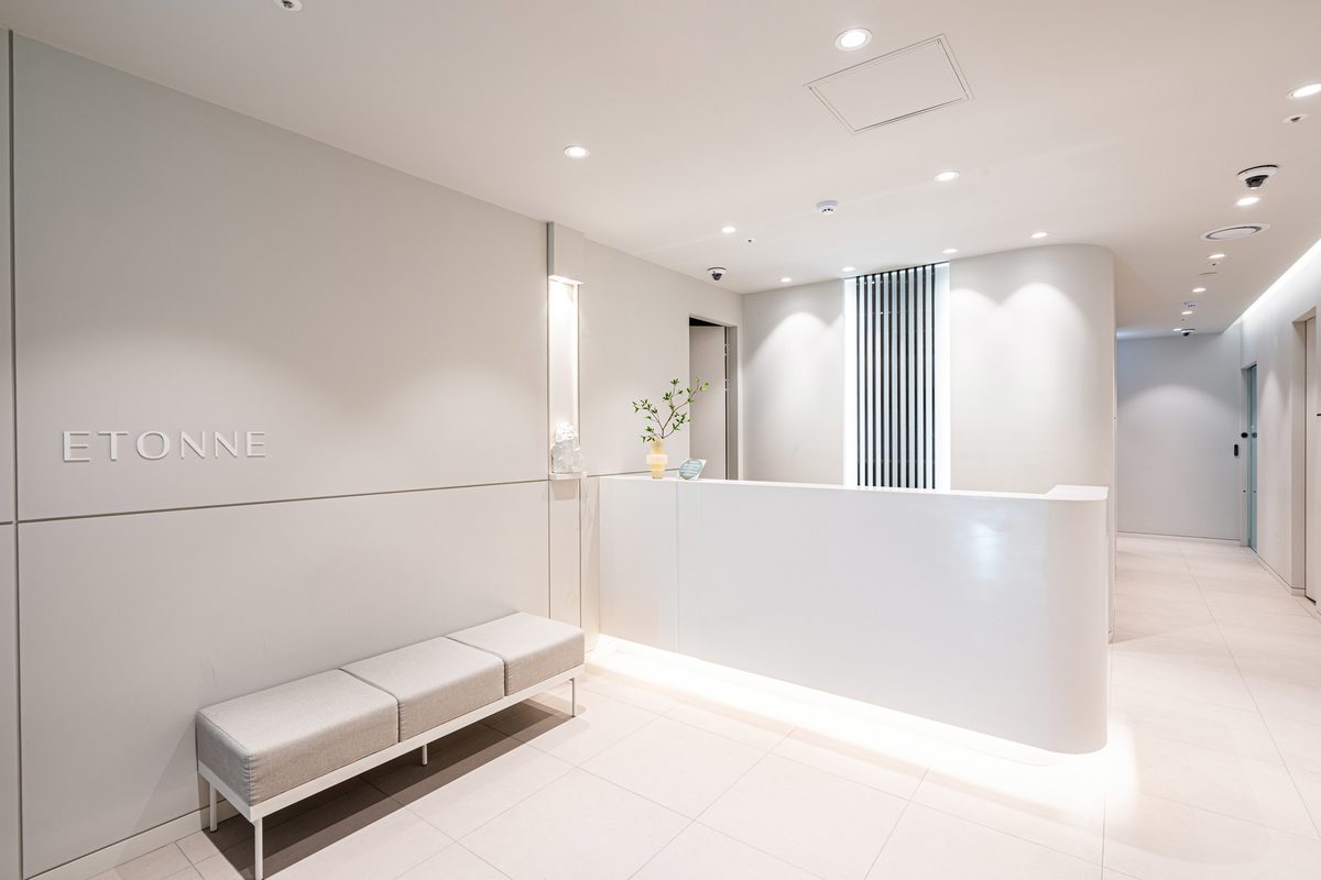 Corridor with the ETONNE wordmark on the wall beside a curved reception desk
