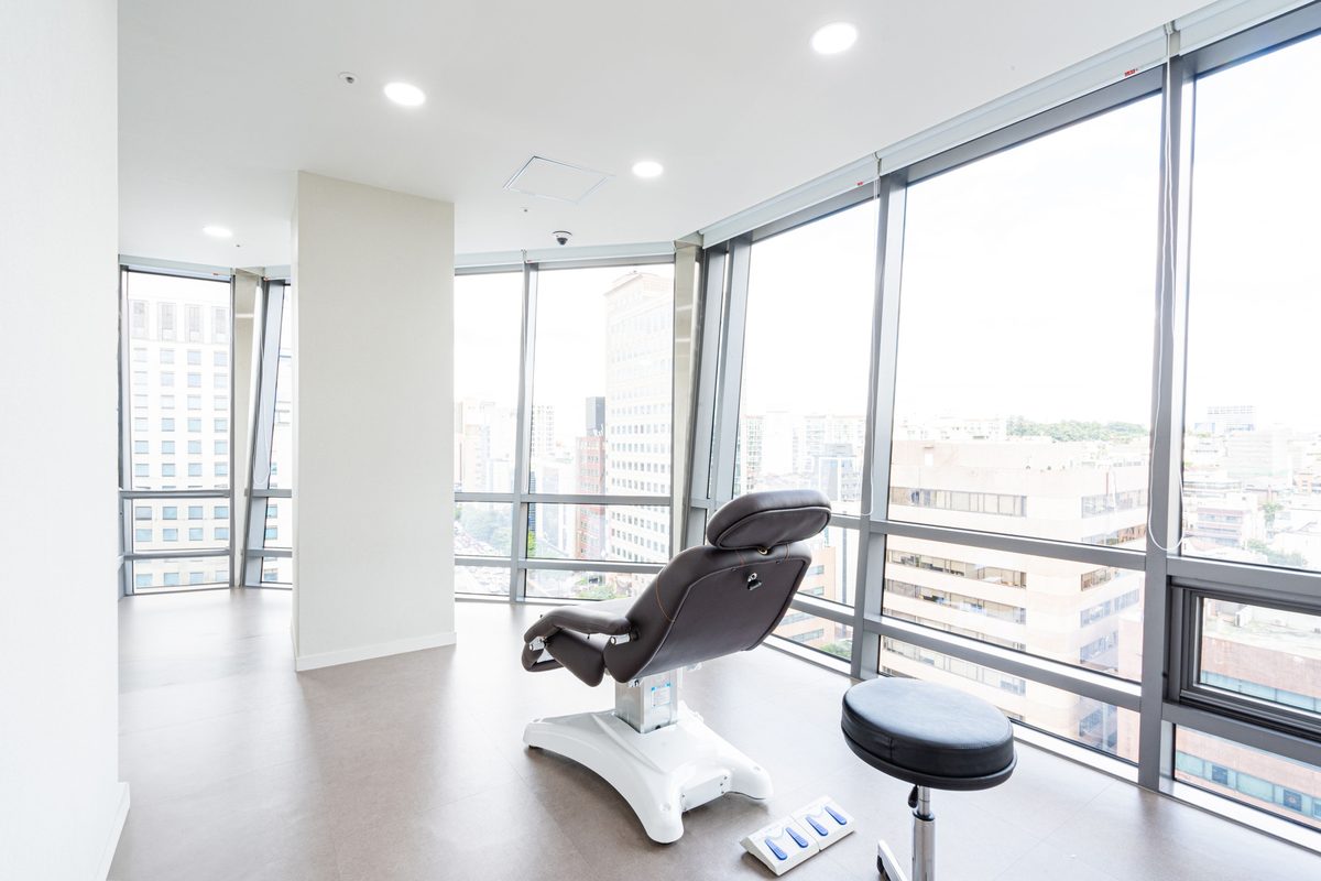 Treatment chair beside floor-to-ceiling windows overlooking the city